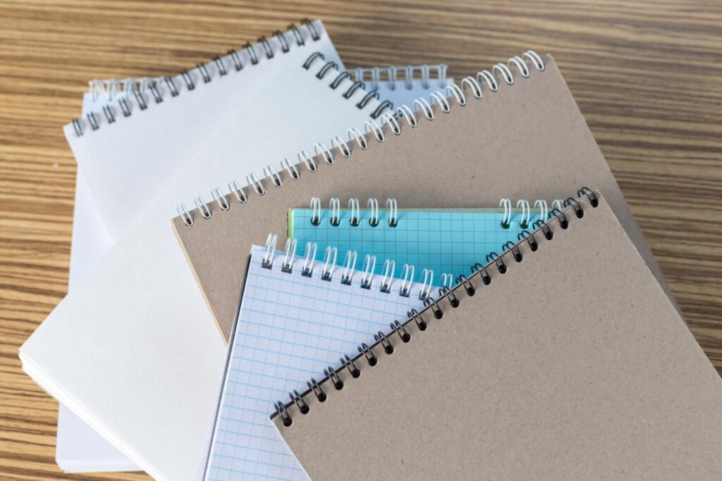 Cuadernos de espiral y libros sobre mesa de madera