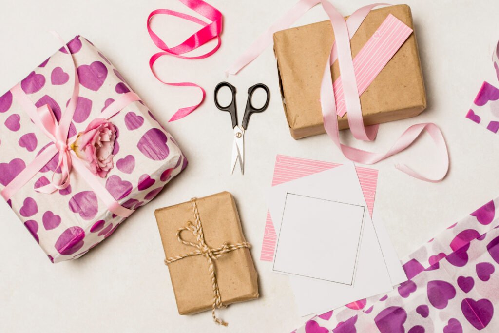 Envoltorio de regalos con papel craft, lazo rosa y tijeras