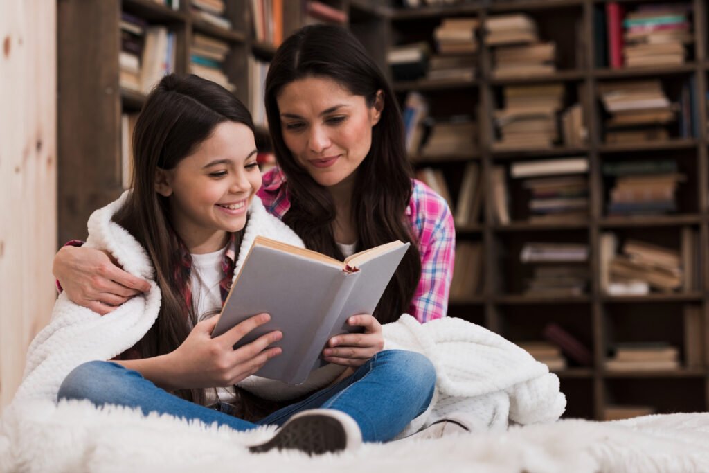 Dos niñas leyendo un libro juntas en el suelo